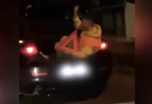 Transporta un pasager în portbagaj cu un triunghi reflectorizat în mână